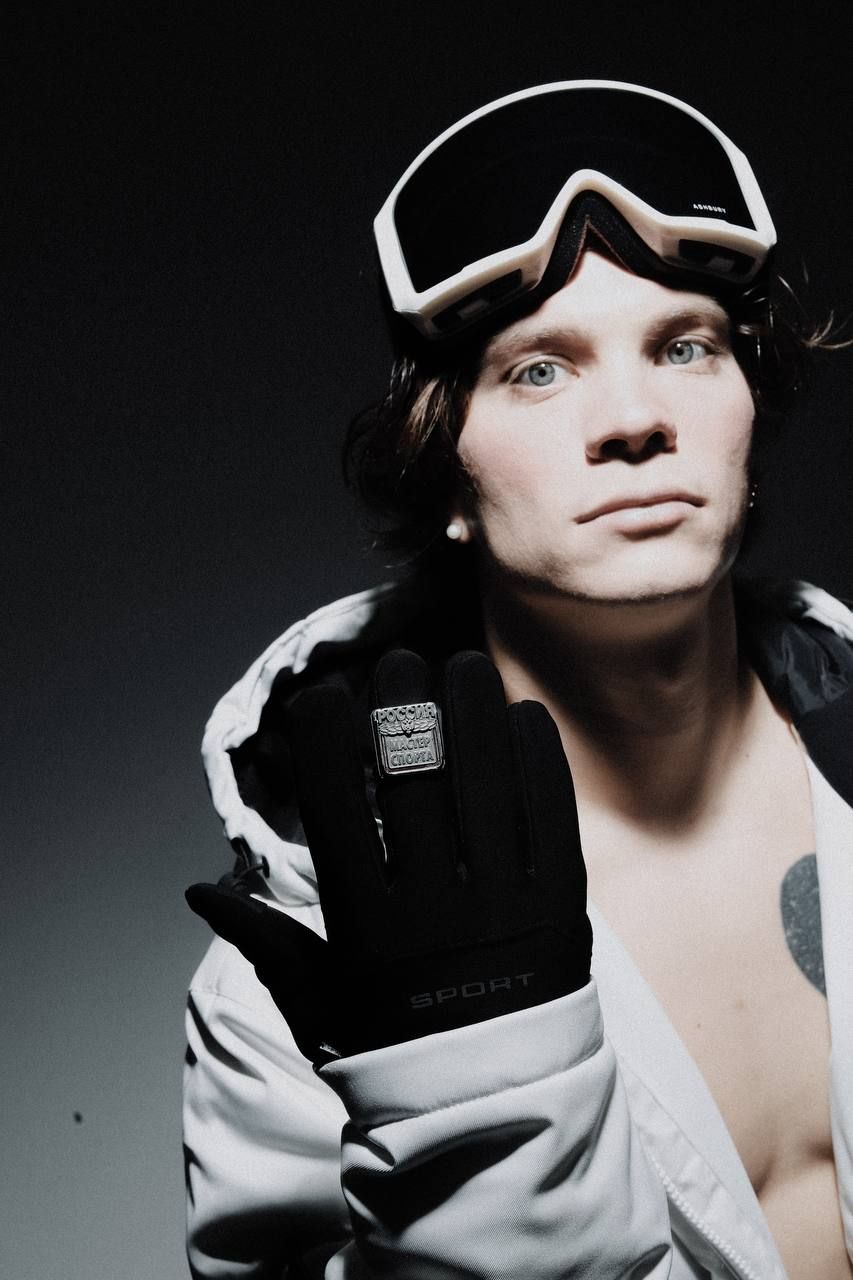 Ilia Baskakov in white goggles, holding up a hand with his ring